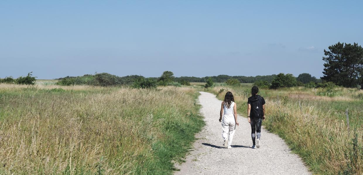 To kvinder går på en sti i det åbne landskab